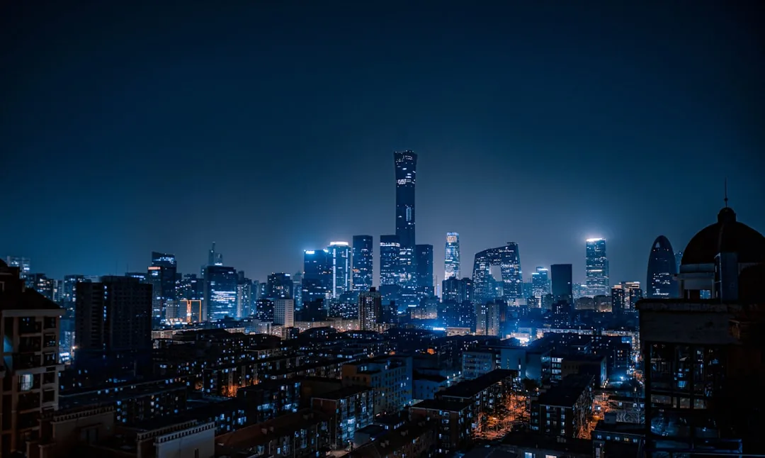 Beijing's CBD skyline at night, including the CCTV Tower and surrounding skyscrapers.