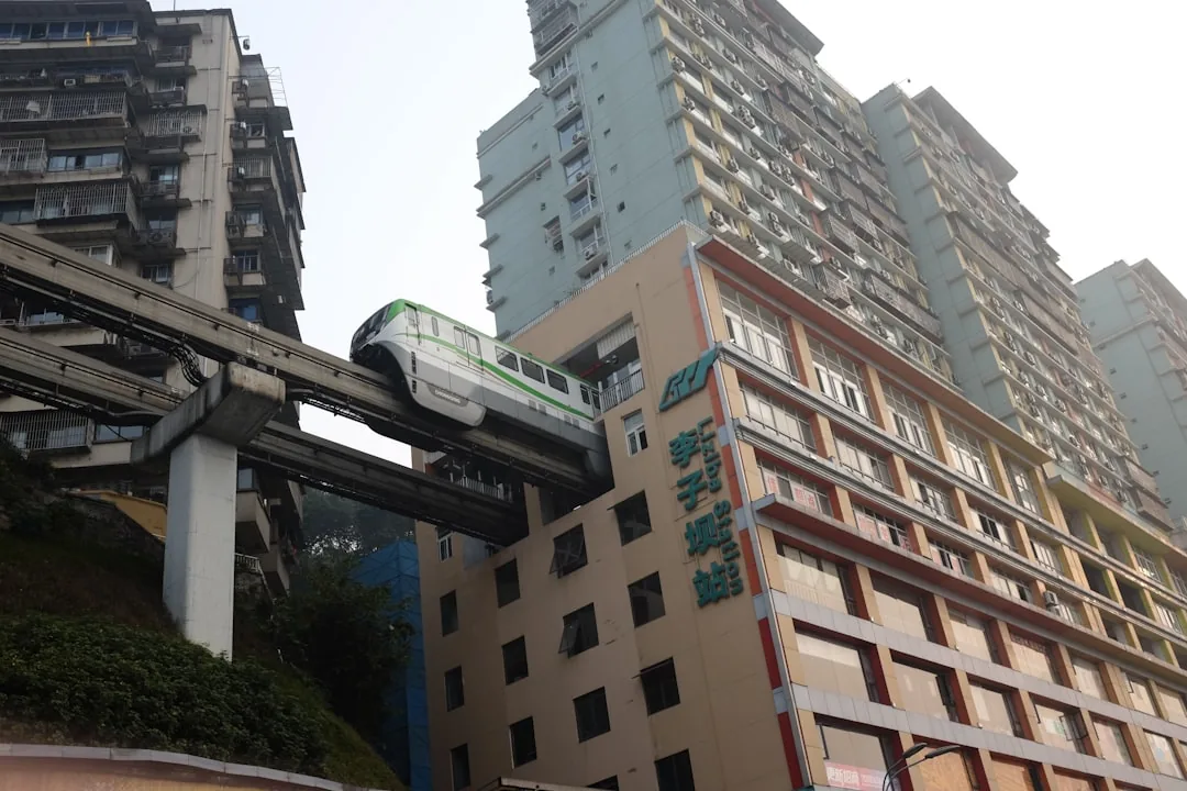 A Chongqing monorail train passing through a city building.