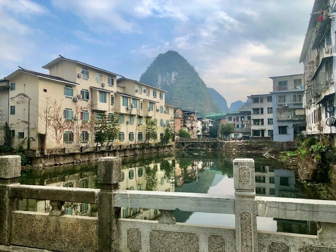 Waterside buildings in Yangshuo with karst peaks rising behind the town.