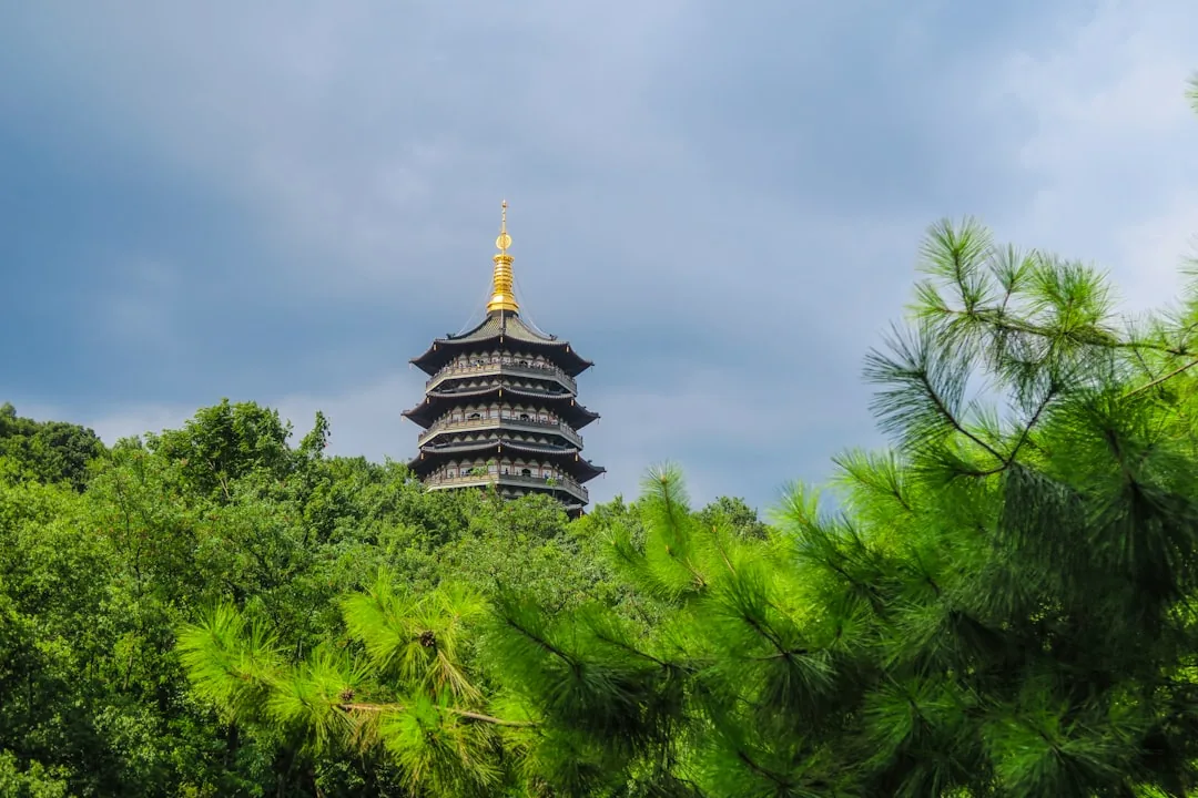 Leifeng Pagoda in Hangzhou rising behind trees near West Lake.