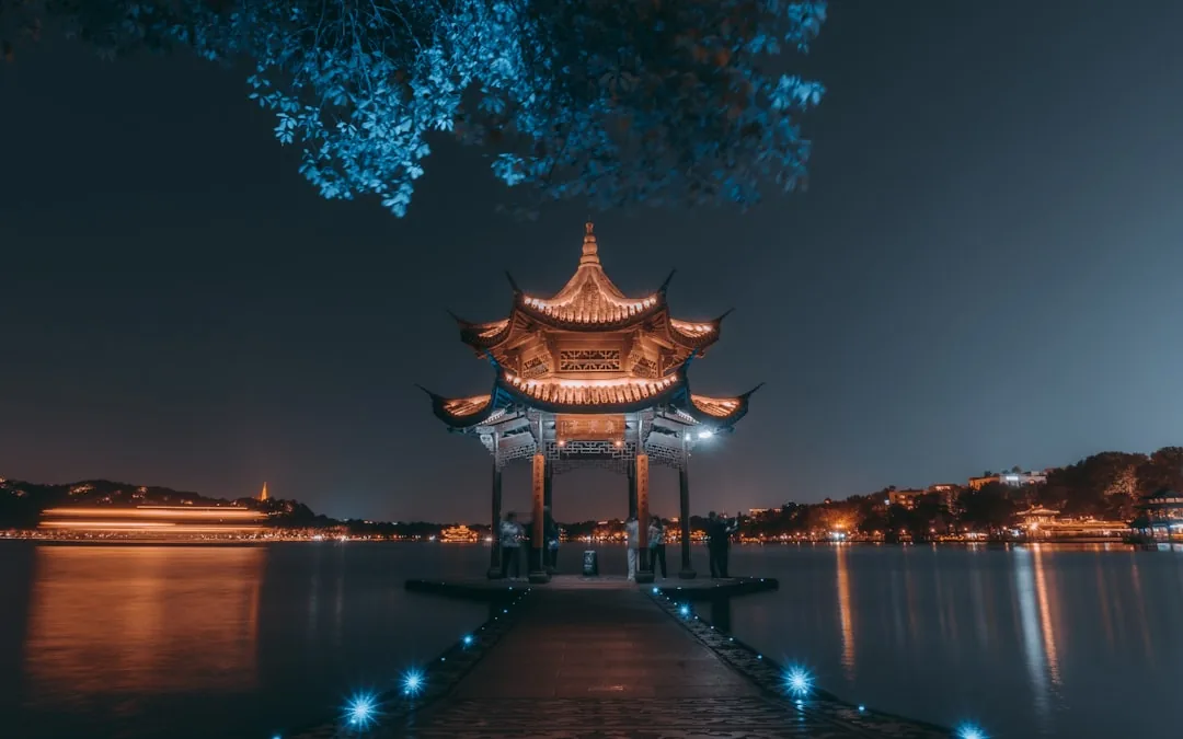 A lakeside pavilion at Hangzhou West Lake with still water and evening light.