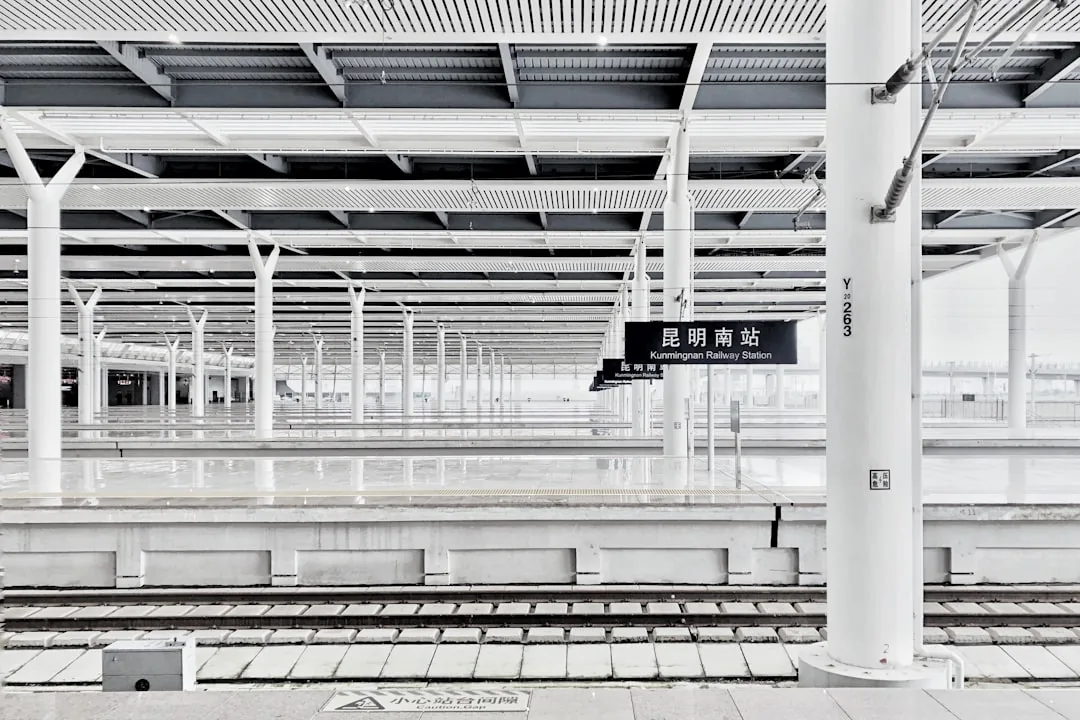Kunming railway station with a white wall and open platform area.