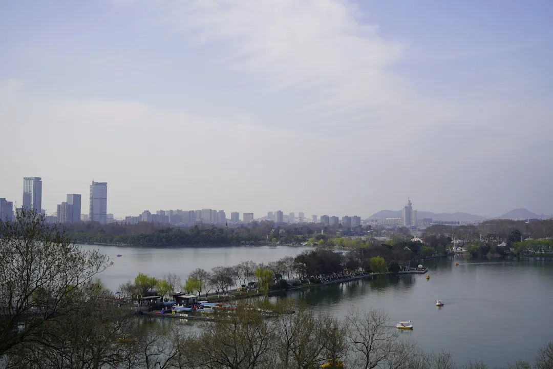 Xuanwu Lake in Nanjing with boats and the city skyline in the background.
