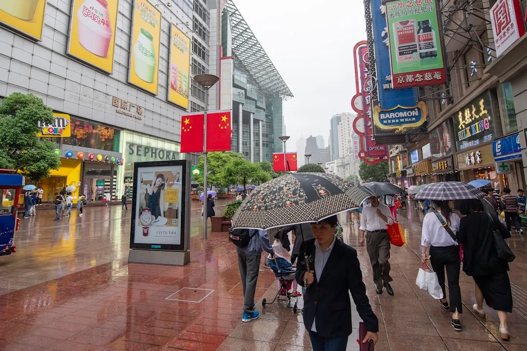 Pedestrians and neon signage on Nanjing Road in Shanghai at night.
