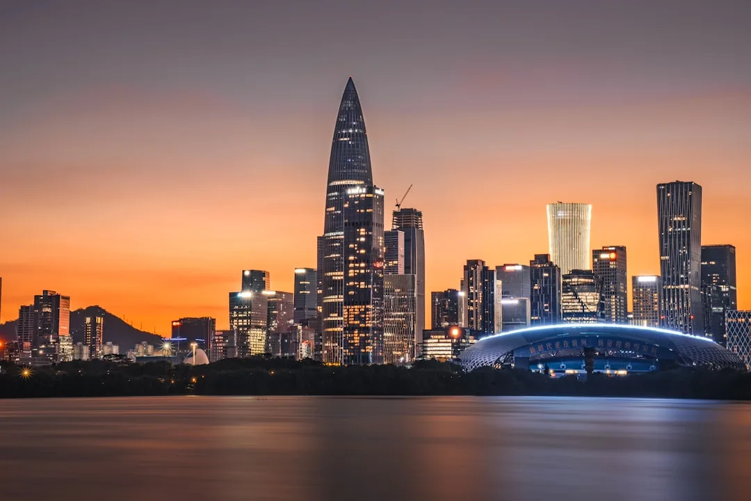 The modern Shenzhen skyline at sunset across the water.