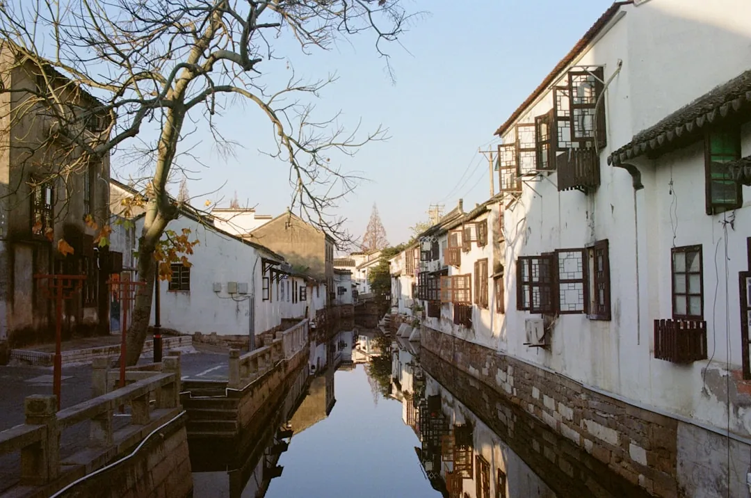 White riverside buildings and a calm canal in a Suzhou water-town setting.