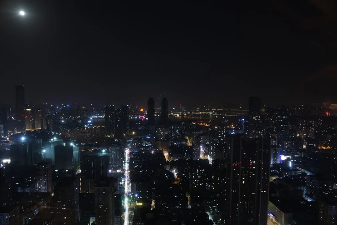 Wuhan skyline illuminated at night with distant city lights.