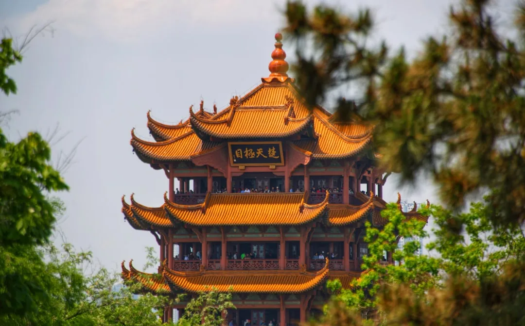 Yellow Crane Tower in Wuhan rising above trees with its golden roof.