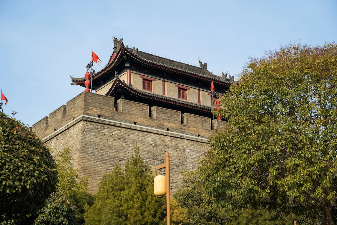 The ancient Xi'an City Wall with brick ramparts and red flags above the old city.