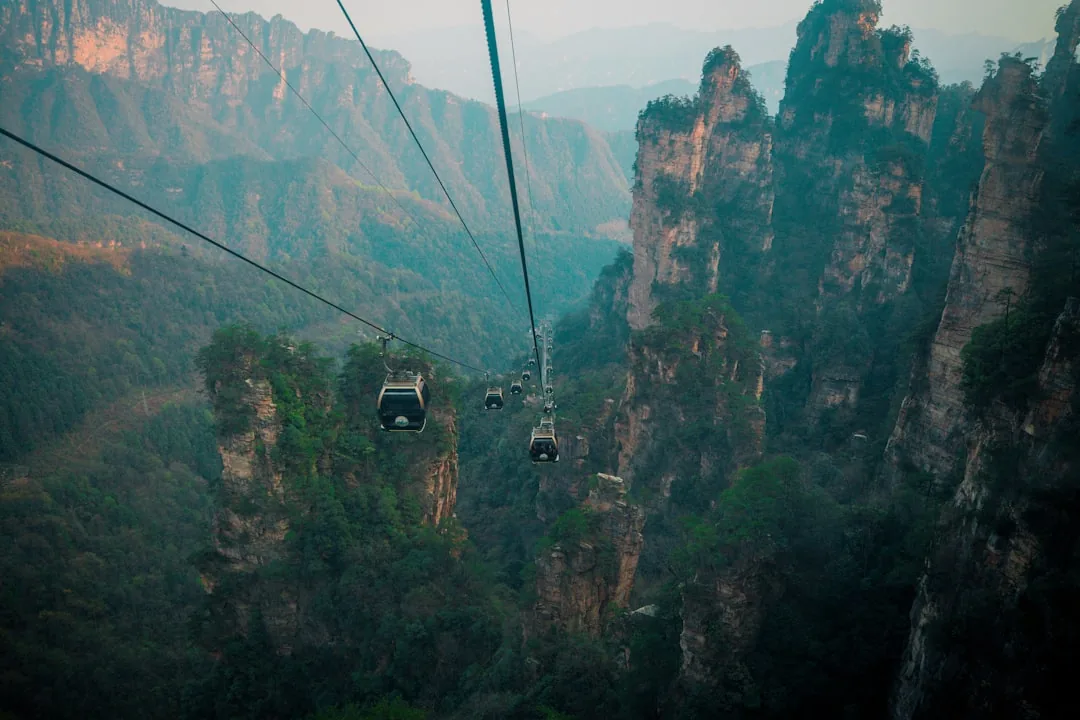Tianmen Mountain cable cars crossing the cliffs and forested peaks near Zhangjiajie.